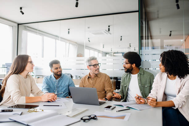 istock Colleagues engage in a lively exchange of ideas in an office 2155493452