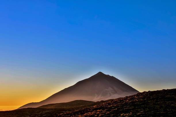 istock A mountain is silhouetted against a blue sky 2155494816