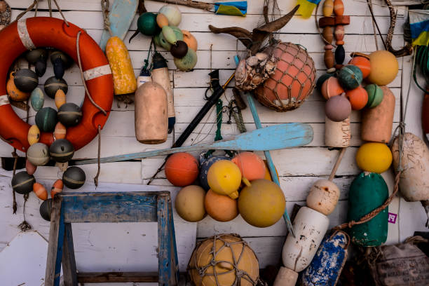 Lobster traps stacked neatly on a pier in Nova Scotia. Tangled ropes and buoy markers hint at a long day's work.