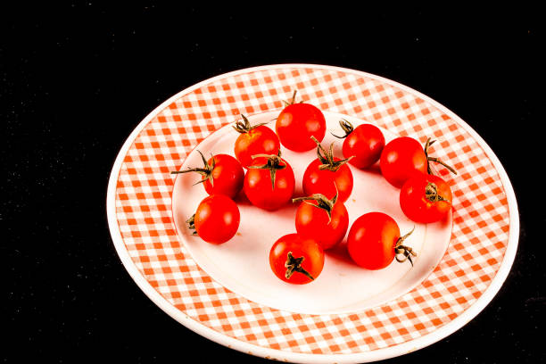 A plate of red tomatoes arranged in a checkered pattern, image