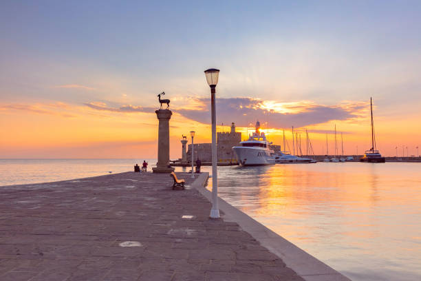Mandraki Harbor with iconic deer statue on column and St Nicholas Fortress in Rhodes, Greece