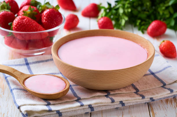 istock strawberry smoothie in a wooden bowl with fresh strawberry on a white table, selective focus. 2155497383