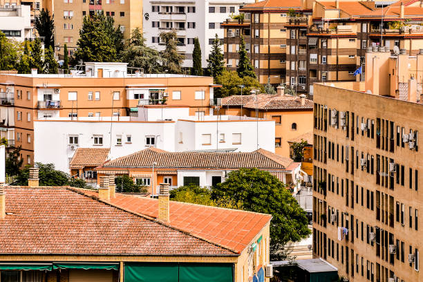 A cityscape with brown and white buildings and a red roof. The buildings are tall and have many windows, image