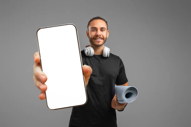 istock Happy man showing smartphone screen on grey background 2155498282