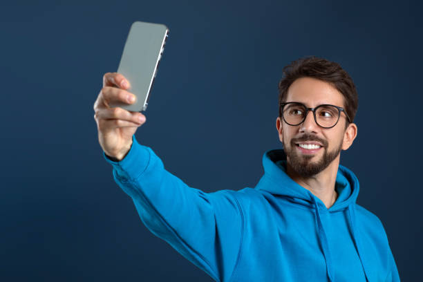 istock Handsome young man in eyeglasses taking selfie on smartphone 2155498542