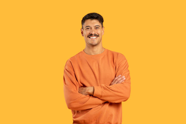 istock Smiling man with arms crossed on yellow 2155498589