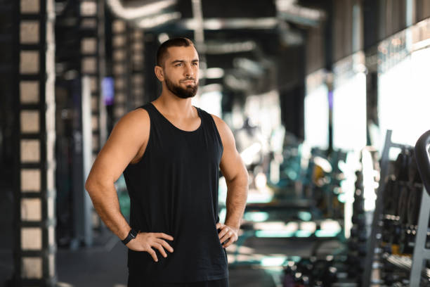 istock Workout Motivation. Young Muscular Male Holding Hands On Hips While Standing At Gym 2155498595