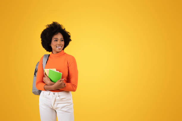istock A cheerful young student with a natural afro hairstyle stands 2155498674