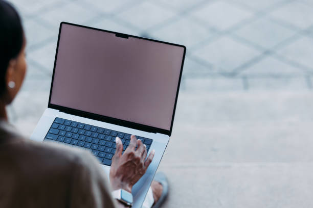 istock Person Working on Laptop with Blank Screen Outdoors 2155498749