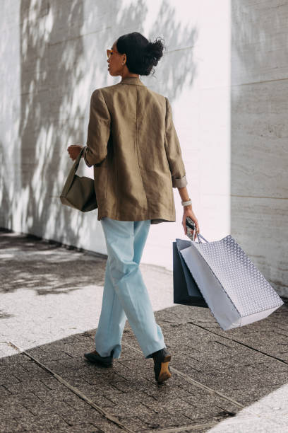 istock Stylish Woman Walking Outdoors with Shopping Bags 2155498764
