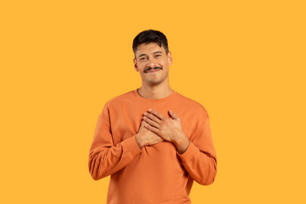 istock Smiling man in orange shirt on yellow 2155498890