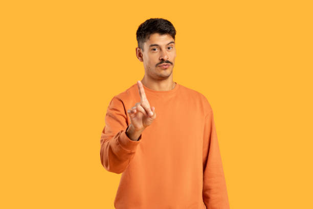 istock Man in Orange Sweater Points at Something 2155499020