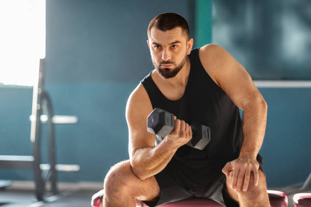 istock Motivated Muscular Man Training With Dumbbell In Modern Gym 2155499029