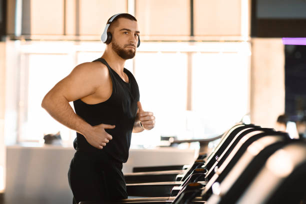 istock Dedicated Man Running on Treadmill in a Modern Gym 2155499156