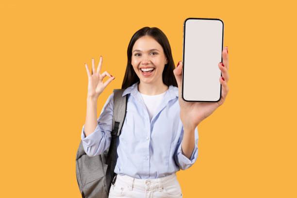 istock Happy female student showing cellphone with OK sign 2155499809