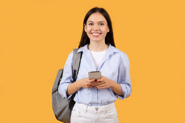istock Young Woman with Phone Looking Pleasantly Surprised 2155499935