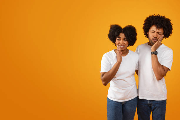 istock Unhappy sick millennial black couple touching their cheeks 2155500458