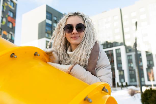istock Woman in Sunglasses Leaning on Yellow Structure 2155501888