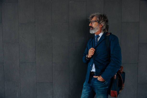 Mature businessman on dark background with copy-space