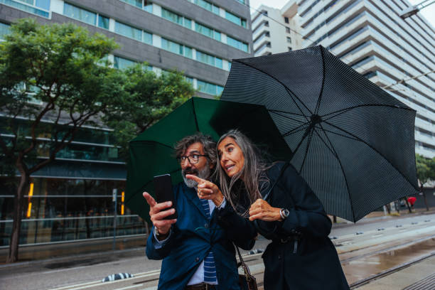 istock Senior businesspeople using a mobile phone outside 2155503116