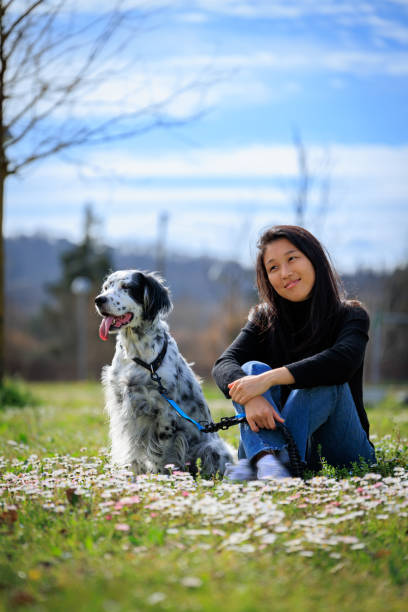 istock Girl sitting in grass with a dog 2155505008