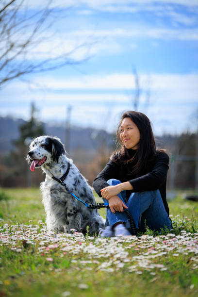 istock Girl sitting in grass with a dog 2155505038