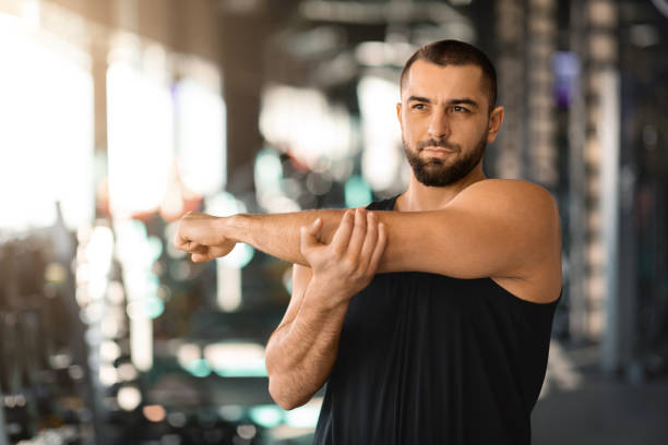 istock Portrait Of Handsome Young Man Warming Up Before Workout In Gym 2155505939