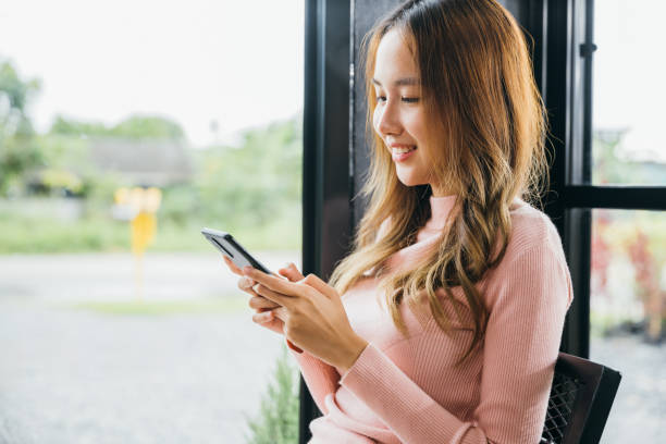 istock Young woman typing text message on smart phone device apps in cafe 2155510620