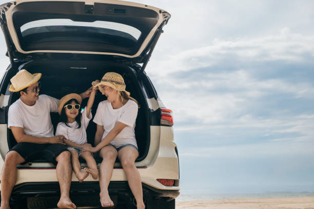 istock People enjoying road trip sitting down on back their car 2155510681