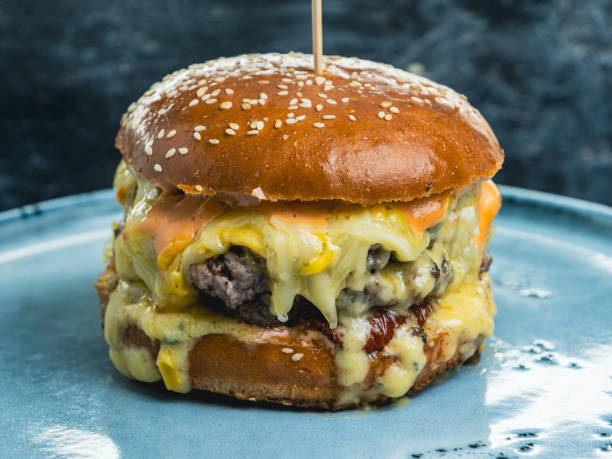 istock Close-up shot of a cheeseburger on a blue plate 2155510690