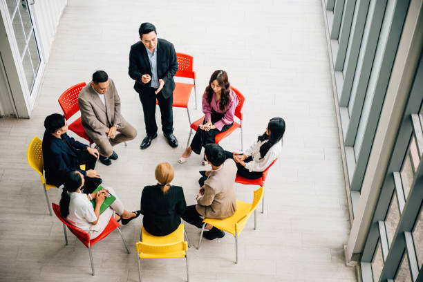 istock Top view of multiethnic professionals in bustling office engaged in teamwork and discussions. Businessman and businesswoman sit at conference leaving copy space. dynamic business meeting in progress. 2155510741