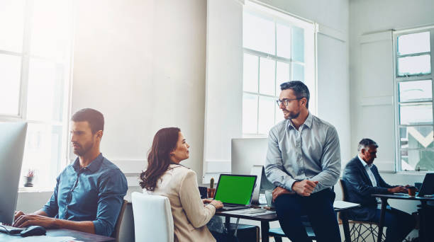 istock Teamwork, laptop green screen and business people in office talking, discussion or conversation. Collaboration, mock up and employees, man and woman planning marketing, advertising or sales project. 2155511306
