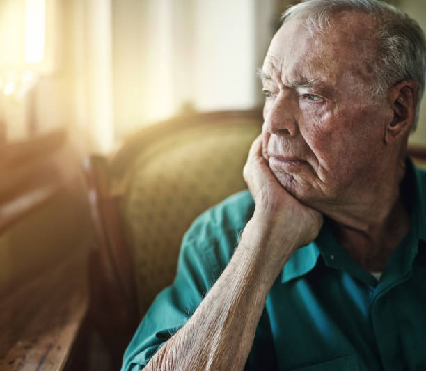 istock Senior, man and thinking with depression for memory in retirement home with remember, nostalgia or reflection on sofa. Elderly, person and sad with alzheimers, grief and thoughtful on couch or mockup 2155511770