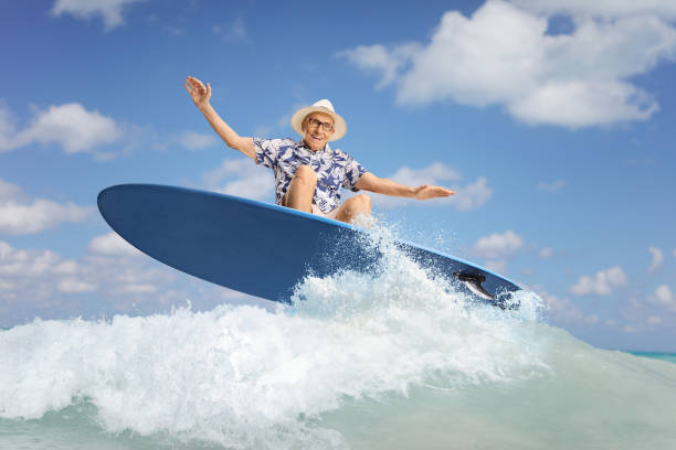 istock Elderly man riding a surfboard on a wave 2155511928