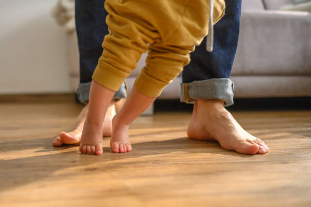 istock Toddler Taking First Steps with Parent Support at Home 2155511948
