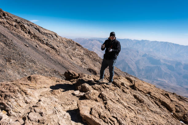 Elbrus mountain range, Iran - October 9, 2023: Climber taking photo while climbing Mount Damavand