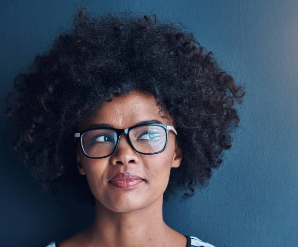 Thinking, afro and black woman with glasses, ideas and problem solving on blue studio background. African person, model and girl with eyewear, solution and planning with decision, choice and wonder