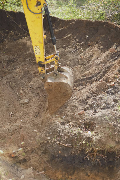 istock Operating excavator bucket in the ground at construction site close-up 2155514629