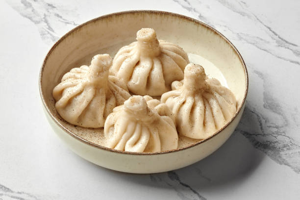 istock Khinkali dumplings sprinkled with black pepper on ceramic plate 2155516245