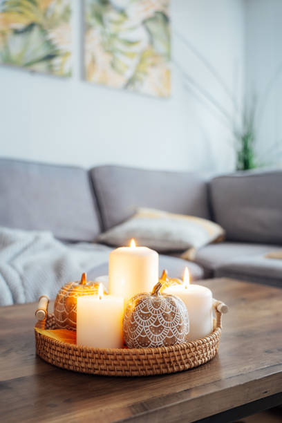 istock Autumn fall cozy mood composition for hygge home decor. Orange pumpkins decorated with mandalas, burning candles on wicker tray on the coffee table in the living room. Selective focus. Copy space. 2155518340