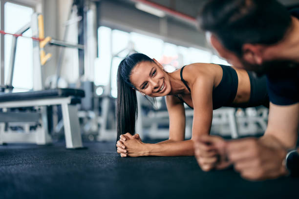 istock Focus on the smiling girl doing a training for abs with her partner, smiling at each other. 2155519369