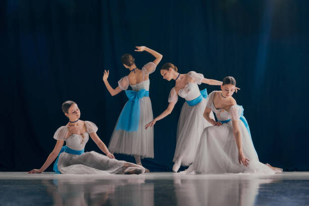 istock Quartet of dancers elegantly poised, each showcasing their unique ballet form in flowing white costumes adorned with blue bows. 2155519963
