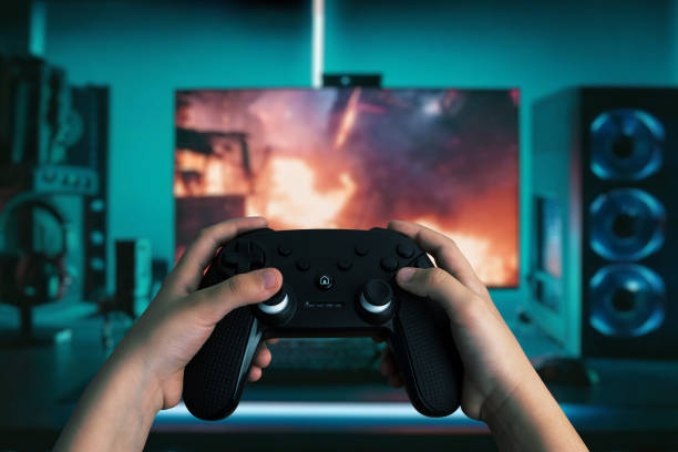 Dynamic image of hands holding a gamepad in front of a modern gaming computer, with vibrant LED lights, playing an action-packed game