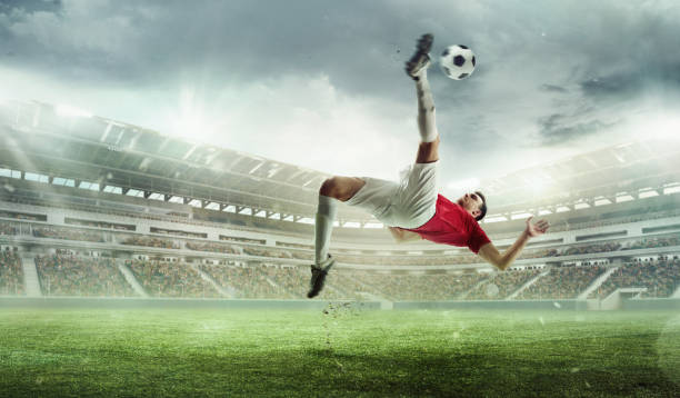 istock Challenging goal. Man, soccer player in motion during game hitting ball and falling down on grass. Winning match. 3D stadium. 2155520783