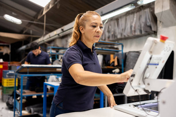 istock Woman working at a shoe factory operating a leather cutting machine 2155521025