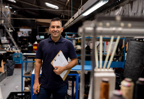 istock Happy foreperson working at a shoe factory 2155521036