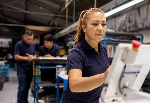 istock Employee working at a shoe factory operating a cutting machine 2155521037