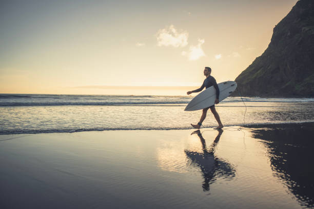 istock Mid adult man with surfboard on the beach. 2155521732