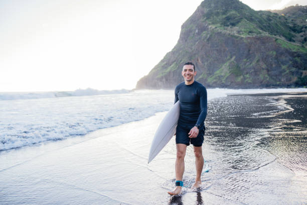 istock Mid adult man with surfboard on the beach. 2155521741