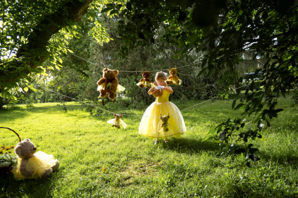 istock Girl with basket under teddy bear clothesline in park. 2155521809